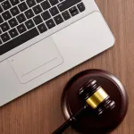 gavel on table next to laptop